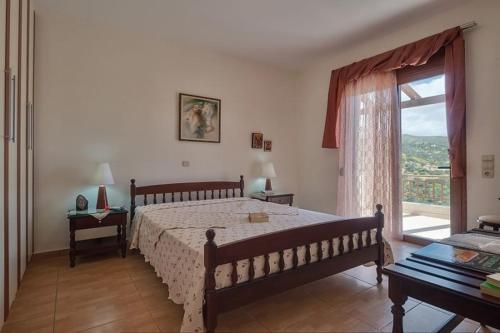 トリオペトラにあるVilla Nikos with Private Poolのベッドルーム1室(ベッド1台、大きな窓付)