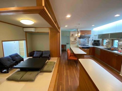 a living room with a couch and a kitchen at 貸切別荘カリイ Vacation Rental KALLY Naha Okinawa in Naha