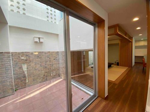 那覇市にあるVacation Rental Kally Naha Okinawaの大きな窓とレンガの壁が備わる客室です。