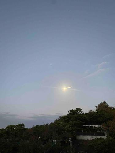 a view of the sun rising over the trees at 貸切別荘カリイ Vacation Rental KALLY Naha Okinawa in Naha