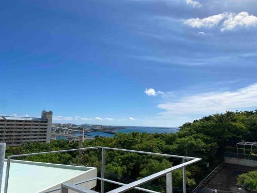 a view of the ocean from the balcony of a building at 貸切別荘カリイ Vacation Rental KALLY Naha Okinawa in Naha