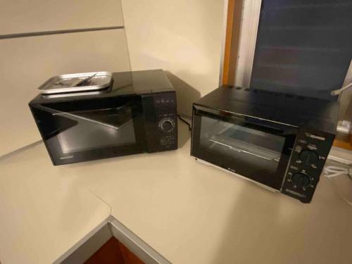 a microwave and a toaster oven on a counter at 貸切別荘カリイ Vacation Rental KALLY Naha Okinawa in Naha