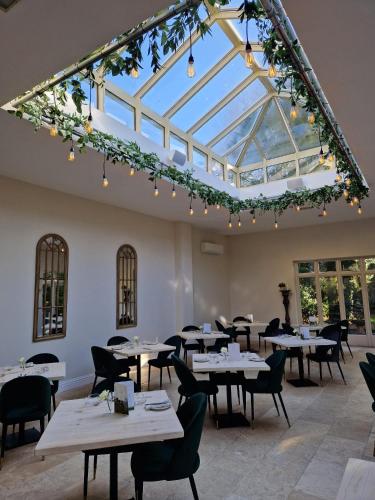 a restaurant with tables and chairs and a glass ceiling at Woodborough Hall in Woodborough