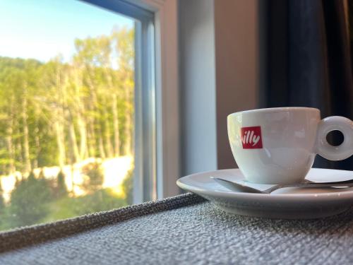 a coffee cup sitting on a table next to a window at Mickitos Apartments - Mavrovo in Mavrovo