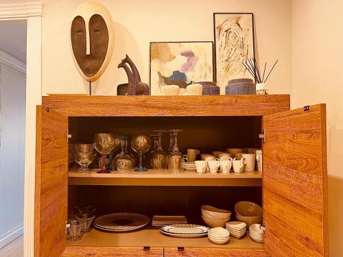 a wooden cabinet filled with plates and dishes at Apartamento de lujo cerca de La Isla del Fraile in Águilas