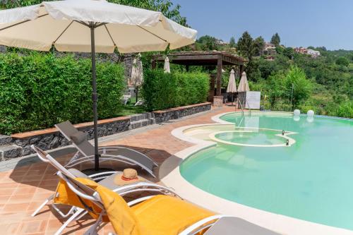 una piscina con 2 sillas y una sombrilla en Etna Sunshine Rent Rooms, en Puntalazzo