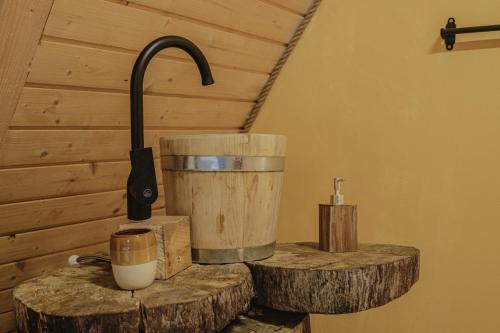 a kitchen counter with a bucket and wooden logs at Waterfall A Frame, Maramures in Baia Mare