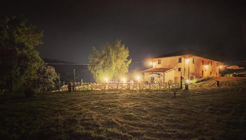a house in a field at night with lights at La valle B&B in Cavriglia