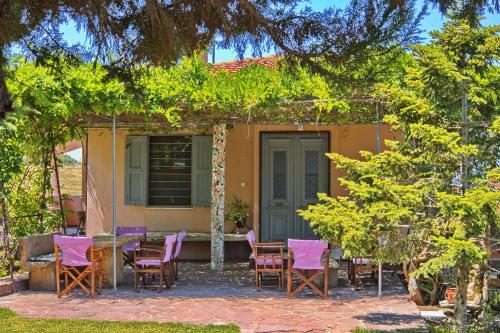 a group of chairs and a table in front of a house at Vintage country house in Halkidiki in Nea Fokea