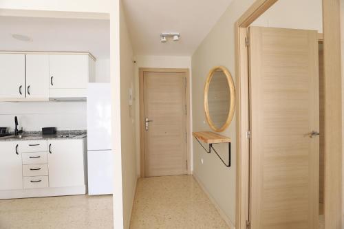 a kitchen with white cabinets and a door with a mirror at Beautiful apartment in Canet Playa. WIFI! in Canet de Berenguer
