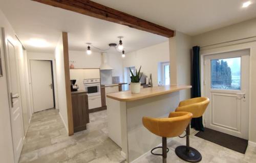 - une cuisine avec un comptoir et 2 chaises dans l'établissement Le Nice Valmontais - draps et serviettes sur demande, à Valmont