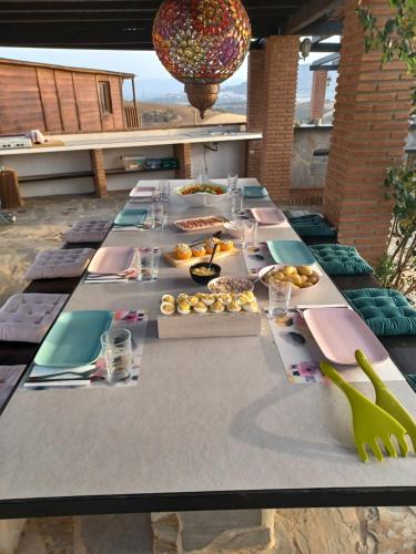 una mesa larga con platos de comida. en B&B Casa Loré D'or en Alora