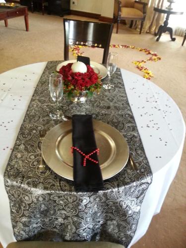 a table with a black and white table cloth and a plate with a napkin at Prinshof Manor Guesthouse in Pretoria