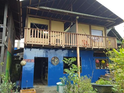 a blue and yellow house with a balcony at Casa Colibrí in Nuquí