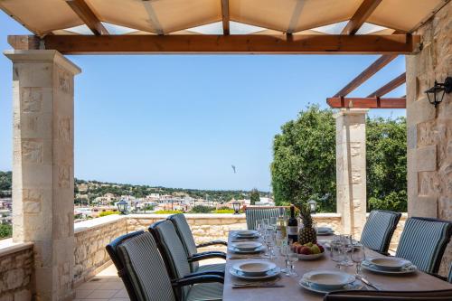 a table and chairs on a patio with a view at Villa Eleftherna in Elefterna
