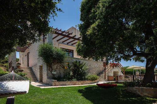 a house with stairs and a yard with green grass at Villa Eleftherna in Elefterna