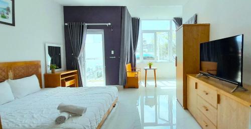 a bedroom with a bed and a flat screen tv at Love Hotel & Apartments in Vung Tau