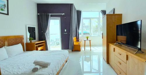 een slaapkamer met een bed en een flatscreen-tv bij Love Hotel & Apartments in Vung Tau