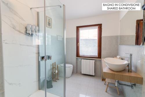 普埃尼亞戈的住宿－Maeva Guesthouse，一间带水槽、卫生间和玻璃淋浴间的浴室