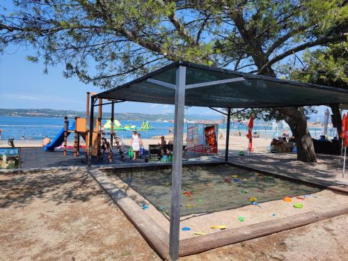 a pavilion at the beach with a playground at Apartma-studio Barbara in Žusterna