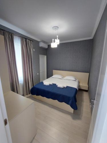a bedroom with a bed with blue sheets and white pillows at Apartment in Sighnaghi in Sighnaghi
