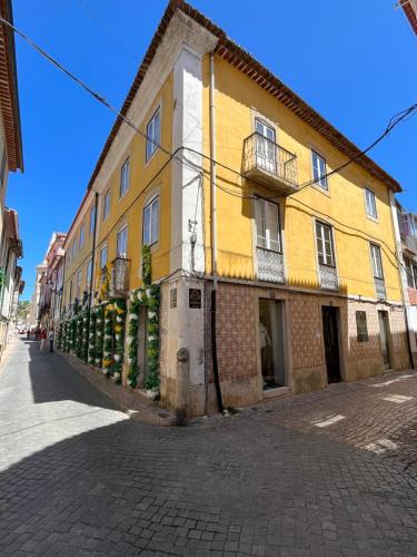 un edificio amarillo y blanco al lado de una calle en Alojamento VINTAGE BAIXA - TOMAR en Tomar