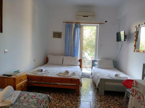 Zimmer mit 2 Einzelbetten und einem Fenster in der Unterkunft Anna Apartments in Agiokampos