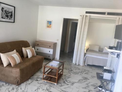 un salon avec un canapé et un lit dans l'établissement jardins croisette PRES CROISETTE, à Cannes