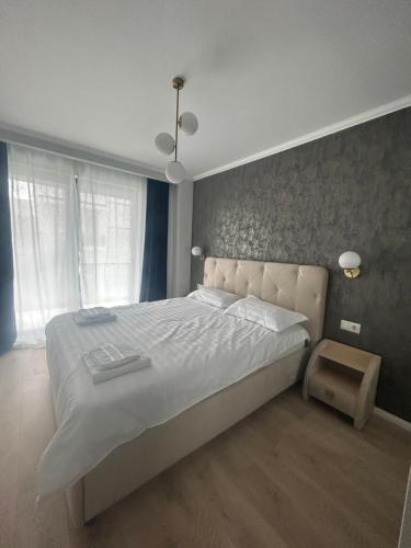 een slaapkamer met een groot bed en een raam bij Apartamente Cluj in Floreşti