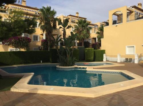 a swimming pool in front of a building at Nice 4 Person apartment residence La Sella Golf Resort Marriott Denia in Pedreguer