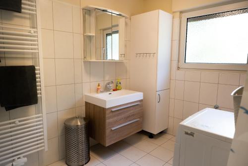 Un baño blanco con lavabo y espejo. en Ferienwohnung zum Märchenwald, en Bergfreiheit