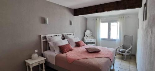 - une chambre dotée d'un grand lit avec des draps et des oreillers roses dans l'établissement La flemme en rose, à Aigues-Mortes