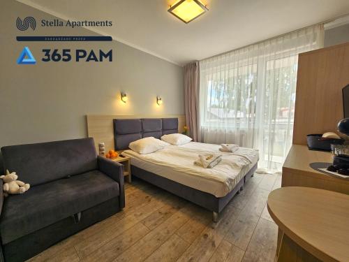 Habitación de hotel con cama y silla en Dominikana Studio Apartamenty - 365PAM, en Sianożęty