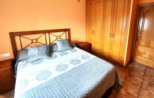 a bedroom with a bed with a blue and white comforter at Planta baja con jardín en Llívia in Llivia