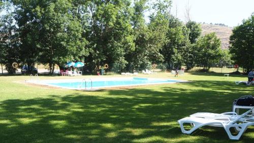 a swimming pool with two lounge chairs in a park at Planta baja con jardín en Llívia in Llivia