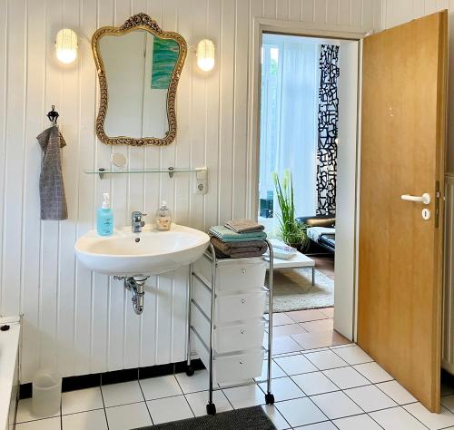 a bathroom with a sink and a mirror on the wall at Ferienapartment Kastanje in Groß Ippener