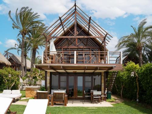 une maison avec un grand toit et une terrasse dans l'établissement Laguava Resort, à Ar Rumaylah
