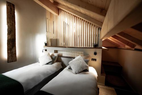 two beds sitting in a room with a window at La Loge de la Dolarde - Chambre Sud in Prémanon