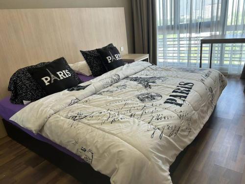 ein Bett mit einer weißen Bettdecke und schwarzen Kissen in der Unterkunft Amy*USS@The Springs Mall in Kuching