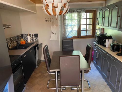a kitchen with a table and chairs in it at Prés de Luchon, Maison Moderne in Guran