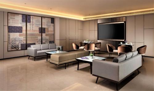 a lobby with couches and a flat screen tv at Courtyard by Marriott Vadodara in Vadodara