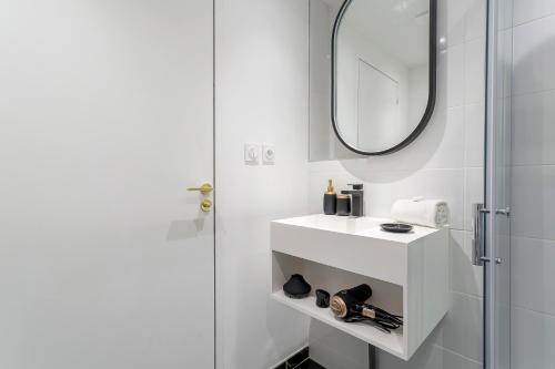 une salle de bain blanche avec un lavabo et un miroir dans l'établissement Très beau studio - Lyon 3, à Lyon