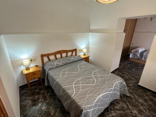 ein Schlafzimmer mit einem Bett und zwei Tischen mit Lampen in der Unterkunft Casa Cele 
