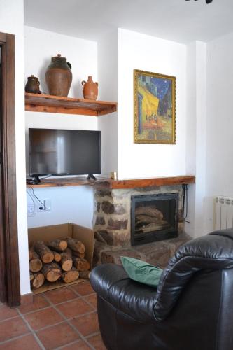 a living room with a couch and a fireplace at Apartamentos La Sierra in Villalba de la Sierra