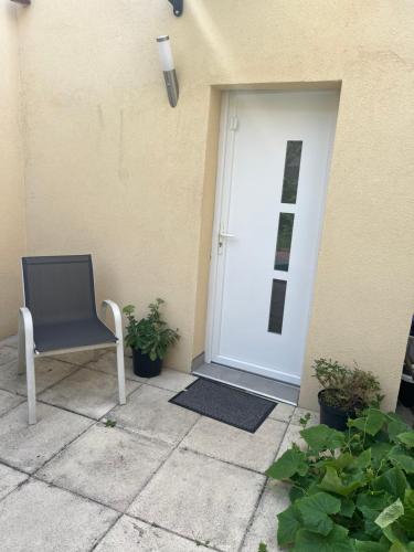 einem blauen Stuhl vor einer Tür in der Unterkunft Grand studio pour 1 ou 2 personnes in Schiltigheim