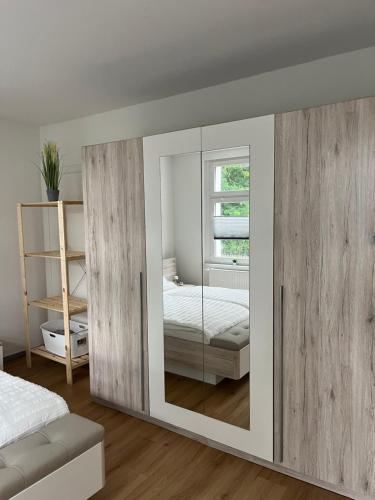 een slaapkamer met een spiegel, een bed en een raam bij Gemütliche und moderne Ferienwohnung in der Innenstadt in Pasewalk