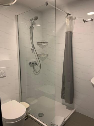 een badkamer met een glazen douche met toilet bij Village Point Apartments in Sliema