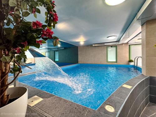 a swimming pool with a waterfall in a building at Luxury Apartments Erol in Sarajevo