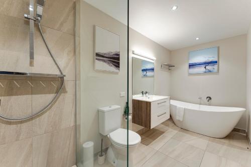 uma casa de banho com uma banheira, um WC e um lavatório. em Queenstown Lake and Mountain View Retreat Free Wifi Free Street Parking em Queenstown