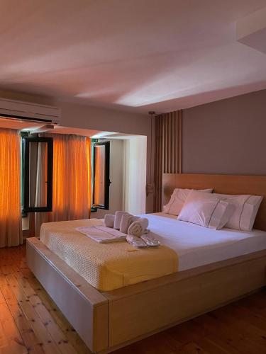 a bedroom with a large bed with towels on it at Cozy Residences in the center of Volissos Village - Lydia Lithos- in Volissos